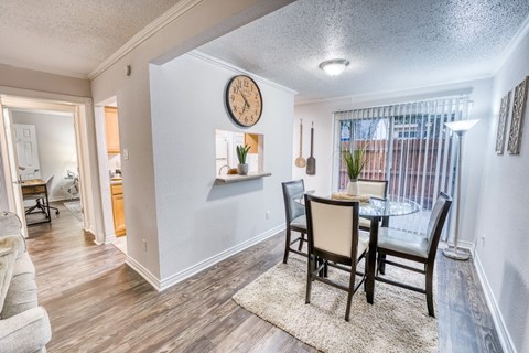 a dining room with a table and chairs and a clock on the wall